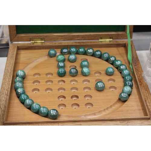 245 - A BOXED WOODEN SOLITAIRE BOARD WITH MARBLES PLUS A VINTAGE CRIBBAGE BOARD