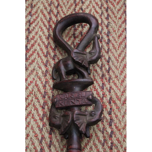 264 - A HAND CARVED AFRICAN WALKING STICK, WITH ELEPHANT FIGURES TO THE TOP, WITH THE INSCRIPTION 'KARIBU,... 