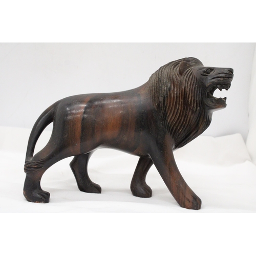 286 - A VINTAGE HARDWOOD CARVED LION, WITH PATINA, WEIGHS NEAARLY 3 KILOS, HEIGHT 20CM, LENGTH 32CM