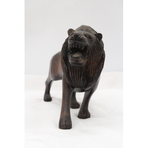 286 - A VINTAGE HARDWOOD CARVED LION, WITH PATINA, WEIGHS NEAARLY 3 KILOS, HEIGHT 20CM, LENGTH 32CM