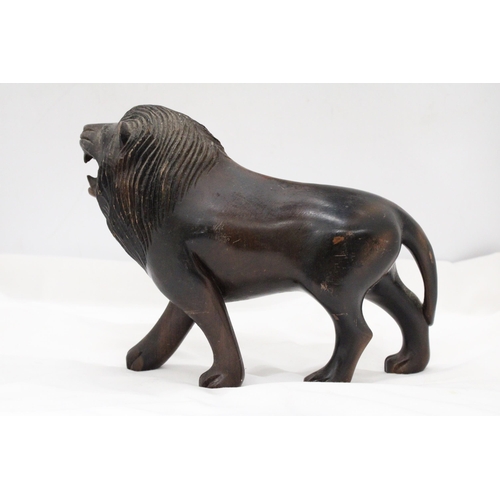 286 - A VINTAGE HARDWOOD CARVED LION, WITH PATINA, WEIGHS NEAARLY 3 KILOS, HEIGHT 20CM, LENGTH 32CM