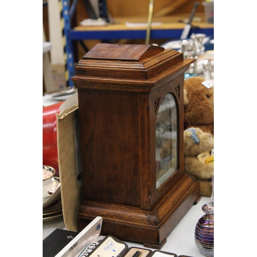 202 - AN EDWARDIAN OAK CASED MANTLE CLOCK WITH PENDULUM, WORKING AT TIME OF CATALOGUING, NO WARRANTY