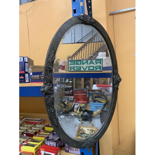 78 - A LARGE OVAL ARTS AND CRAFTS MIRROR