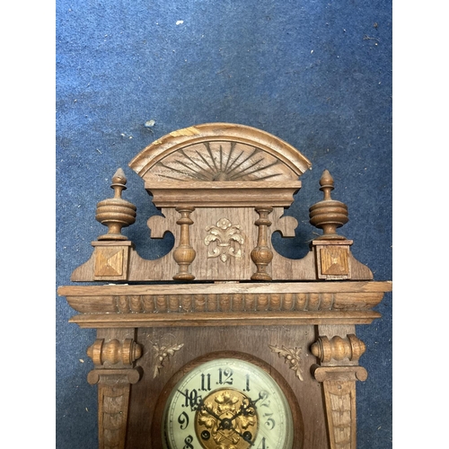 1060 - A VINTAGE OAK CASED WALL CLOCK, WITH CARVED DETAIL AND PENDULUM