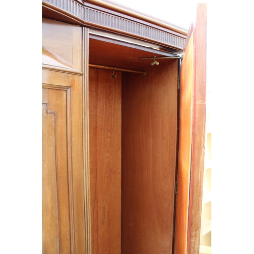 2950 - AN EDWARDIAN MAHOGANY PARTIALLY BOW FRONTED MIRROR-DOOR WARDROBE ON BRACKET FEET, 61