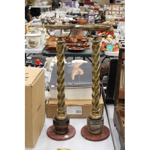 135 - A PAIR OF ANTIQUE BRASS CHURCH CANDLE HOLDERS