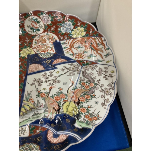 26 - A MEIJI PERIOD JAPANESE IMARI CHARGER WITH SCALLOPED BORDER, HAND PAINTED DECORATIVE SCROLL PANEL OF... 