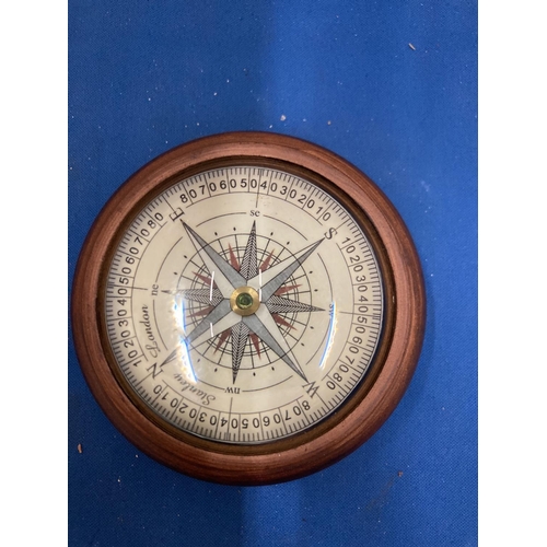 29 - A WOODEN PAPERWEIGHT COMPASS