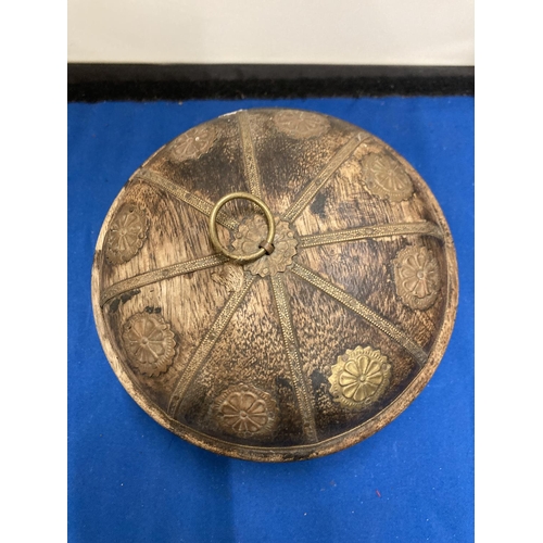 48 - A VINTAGE INDIAN ROUND WOODEN OPIUM/TOBACCO BOX DECORATED WITH HAMMERED METAL FLOWERS