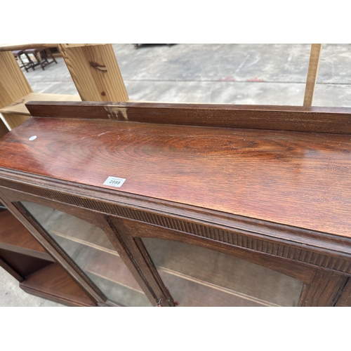 2899 - AN EARLY 20TH CENTURY OAK TWO DOOR DISPLAY CABINET ON OPEN BASE WITH TURNED FRONT LEGS, 35