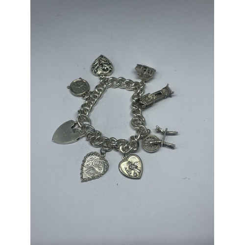 578 - A VINTAGE SILVER CHARM BRACELET WITH SEVEN CHARMS