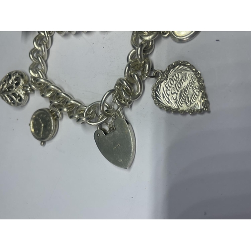 578 - A VINTAGE SILVER CHARM BRACELET WITH SEVEN CHARMS