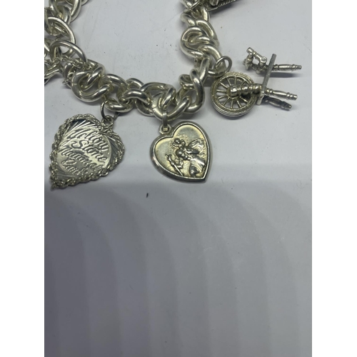 578 - A VINTAGE SILVER CHARM BRACELET WITH SEVEN CHARMS