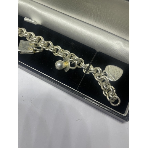 579 - A TIFFANY & CO SILVER CHARM BRACELET WITH SIX CHARMS IN A PRESENTATION BOX