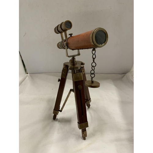 973 - A BRASS AND LEATHER TELESCOPE ON A STAND, HEIGHT 33CM