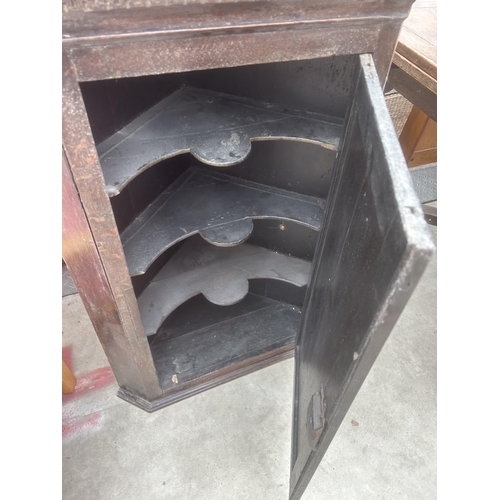 2905 - A GEORGE III OAK CORNER CUPBOARD WITH H BRASS HINGES, DENTIL CORNICE AND SHAPED SHELVES