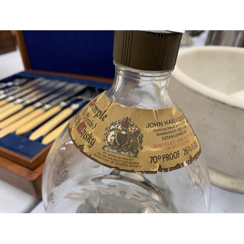 106 - A DIMPLE WHISKY BOTTLE CONTAINING A COLLECTION OF SIXPENCES