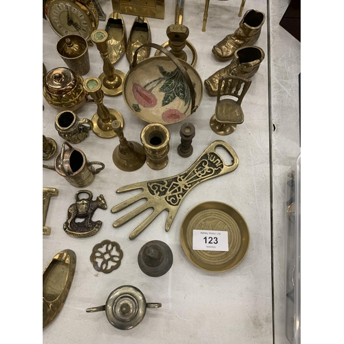123 - A LARGE QUANTITY OF BRASS ITEMS TO INCLUDE CLOCKS, BOTTLE OPENERS, BOOTS, ETC.,