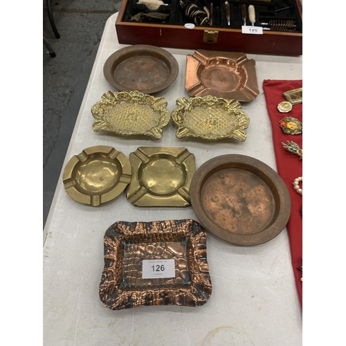 126 - A COLLECTION OF BRASS AND COPPER ASHTRAYS