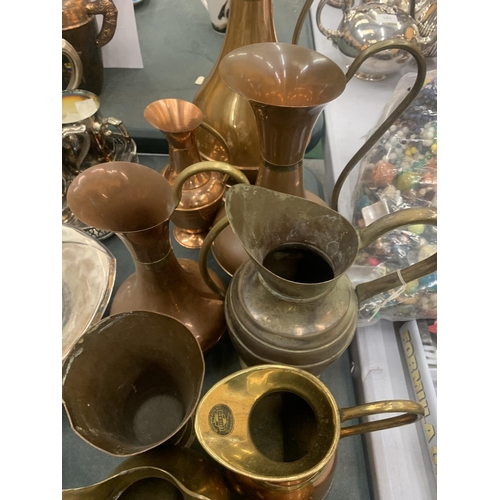 140 - A LARGE COLLECTION OF BRASS AND COPPER JUGS
