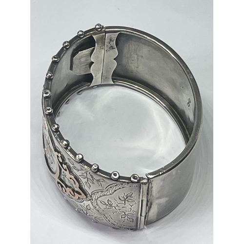 503 - A HALLMARKED BIRMINGHAM 1883 SILVER BANGLE  WITH HAND ENGRAVING AND GOLD FLOWERS ETC IN A PRESENTATI... 