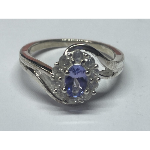 519 - A MARKED 925 SILVER RING WITH CENTRE PURPLE STONE SURROUNDED BY CLEAR STONES ON A TWIST DESIGN SIZE ... 