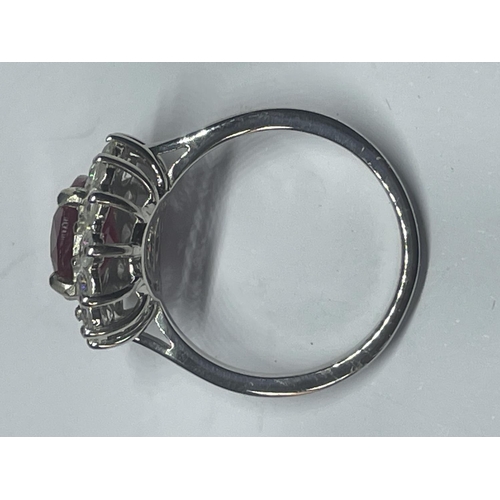 546 - A MARKED 925 SILVER RING WITH CENTRE RUBY COLOURED STONE SURROUNDED BY CLEAR SONES SIZE R IN A PRESE... 