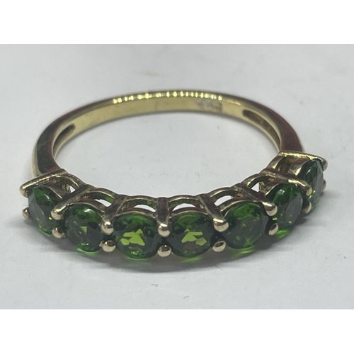 553 - A MARKED 925 SILVER GILT RING WITH SEVEN IN LINE EMERALD COLOURED STONES SIZE L/M IN A PRESENTATION ... 