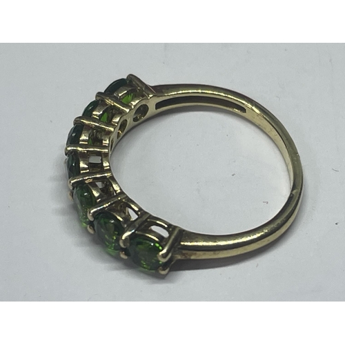 553 - A MARKED 925 SILVER GILT RING WITH SEVEN IN LINE EMERALD COLOURED STONES SIZE L/M IN A PRESENTATION ... 