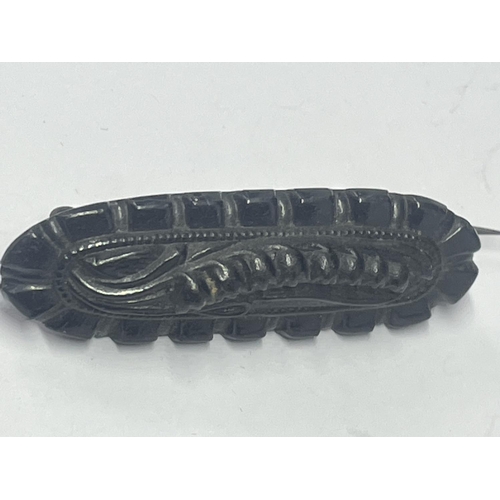 555 - A CARVED JET BROOCH