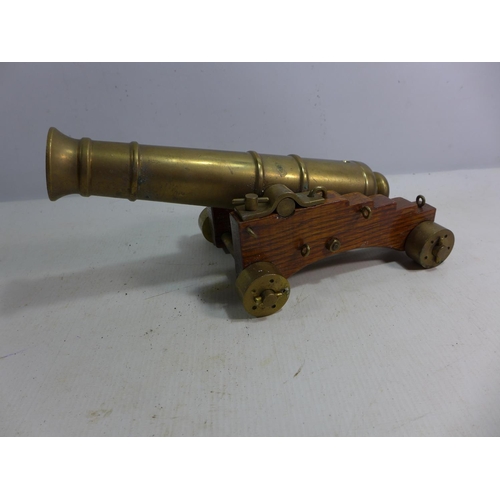 391 - A NON FIRING BRASS MODEL CANON 23.5CM BARREL MOUNTED ON A WOODEN CARRIAGE LENGTH 26CM