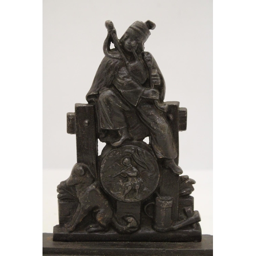 229 - A HEAVY CAST BAG-PIPER AND DOG DOORSTOP ON PEDESTAL