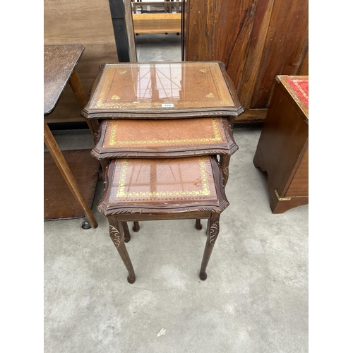 2880 - A LEATHER TOPPED MAHOGANY NEST OF TABLES, OAK TWO TIERED OCCASIONAL TABLE ON CASTERS AND A MAHOGANY ... 