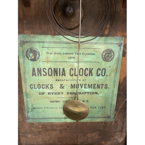 38 - AN ANSONIA CLOCK CO. DECORATIVE WALL CLOCK WITH A DECORATIVE FACE AND TWO GLASS DOORS ONE WITH PAINT... 