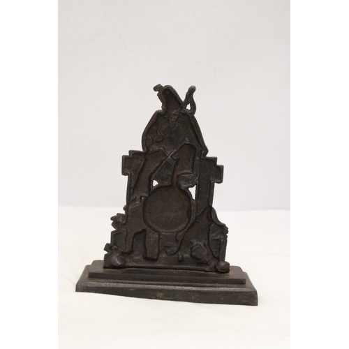 229 - A HEAVY CAST BAG-PIPER AND DOG DOORSTOP ON PEDESTAL