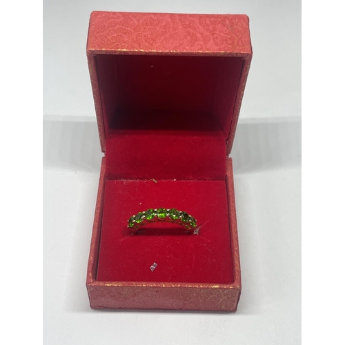 553 - A MARKED 925 SILVER GILT RING WITH SEVEN IN LINE EMERALD COLOURED STONES SIZE L/M IN A PRESENTATION ... 