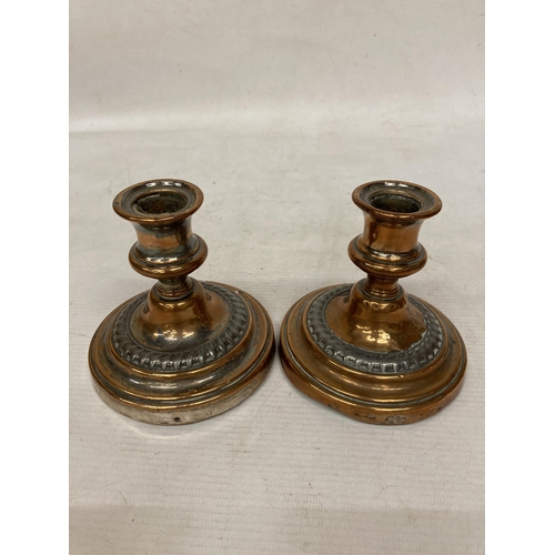 29 - A LARGE HEAVY VICTORIAN COPPER DECORATED BOWL ON A PLINTH WITH A PAIR OF HEAVY COPPER CANDLESTICKS