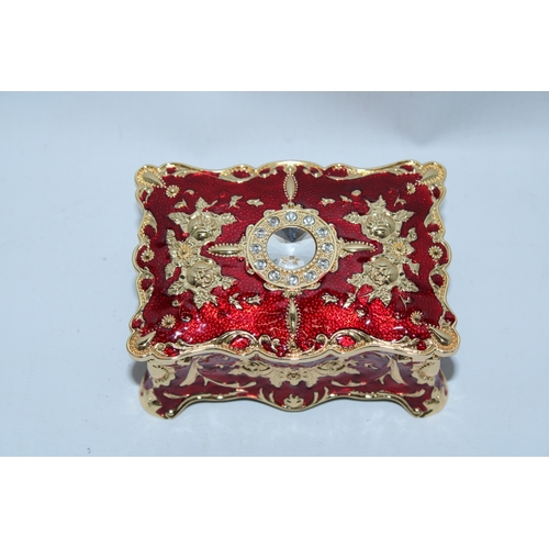 107 - A RED AND GOLD ENAMEL JEWELLERY BOX