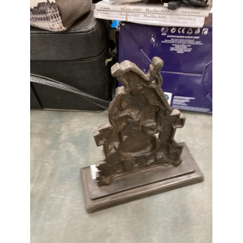 229 - A HEAVY CAST BAG-PIPER AND DOG DOORSTOP ON PEDESTAL