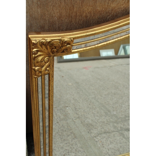 2826 - A GILT EFFECT OVERMANTEL MIRROR WITH DOUBLED MIRRORED EDGE AND FOLIATE DECORATION