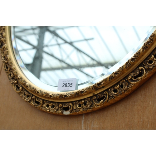 2835 - AN OVAL GILT FRAMED WALL MIRROR, 22