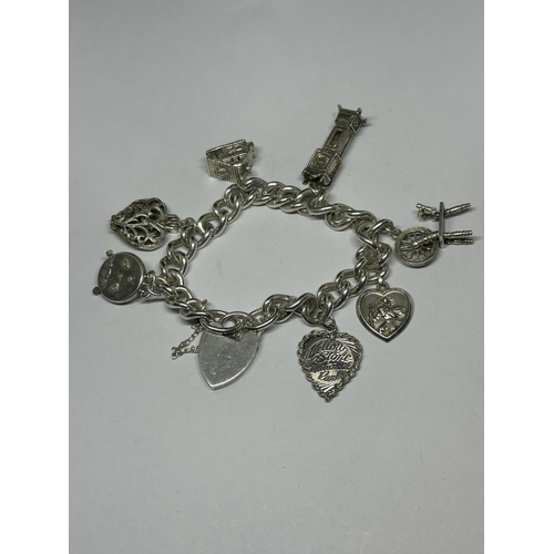 748 - A VINTAGE SILVER CHARM BRACELET WITH SEVEN CHARMS