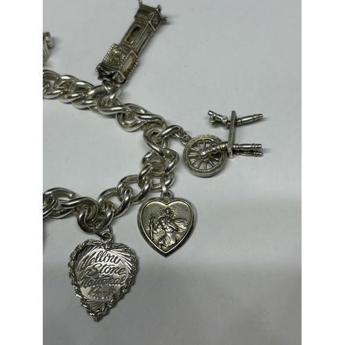 748 - A VINTAGE SILVER CHARM BRACELET WITH SEVEN CHARMS