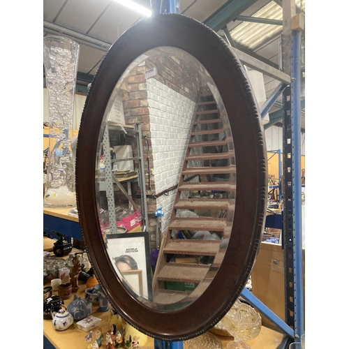 1118 - A LARGE OVAL BEADED MAHOGANY BEVELLED WALL MIRROR  - APPROXIMATELY 89CM X 64CM