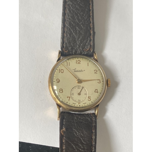 513 - AN EVERITE 9 CARAT GOLD WRISTWATCH WITH BROWN LEATHER STRAP SEEN WORKING BUT NO WARRANTY GIVEN