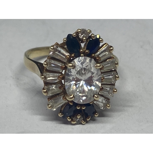 526 - A 14 CARAT DECO STYLE DRESS RING WITH A CENTRE OVAL CLEAR STONE SURROUNDED BY BLUE AND CLEARSTONES S... 