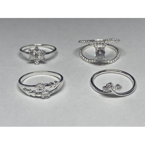 527 - FOUR VARIOUS SILVER RINGS SOME WITH CLEAR STONES