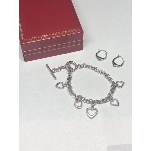 536 - A PAIR OF HEART DESIGN SILVER EARRINGS AND A SILVER CHARM BRACELET WITH FIVE HEARTS IN A PRESENTATIO... 