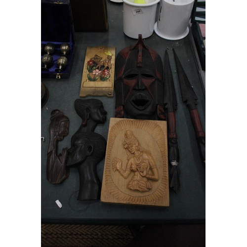 245 - A COLLECTION OF CARVED WOODEN AFRICAN THEMED ITEMS TO INCLUDE WALL MASKS, A PAIR OF SHORT SPEARS, A ... 