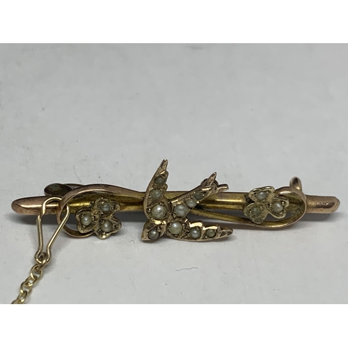 591 - TWO VINTAGE MARKED 9 CARAT GOLD BROOCHES ONE WITH A SEED PEARL SWALLOW DESIGN AND SAFETY CHAIN